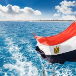 A vibrant Egyptian flag on a boat with clear blue water in Hurghada, Egypt.